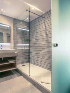 een badkamer met een glazen douche en een wastafel bij Best Western Marseille Aeroport in Vitrolles