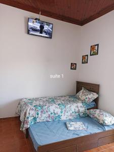 a bedroom with a bed with a tv on the wall at Casa para 12 pessoas perto da Basílica e da Feira in Aparecida