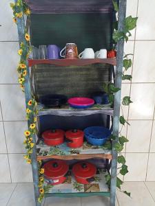 une étagère avec des bols et des assiettes de différentes couleurs dans l'établissement Casa para 12 pessoas perto da Basílica e da Feira, à Aparecida
