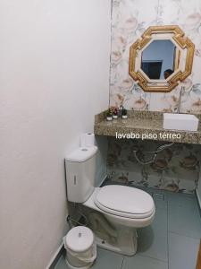 een badkamer met een toilet en een spiegel bij Casa para 12 pessoas perto da Basílica e da Feira in Aparecida