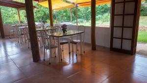 una sala da pranzo con tavoli, sedie e finestre di Pousada Vereda Tropical a Parati Altre 86 foto