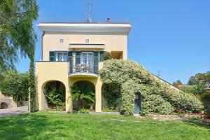a house with a balcony and a yard at Casa Vacanze Nel Giardino di Renzo in Imperia