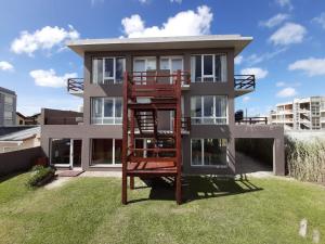 a house with a spiral staircase in front of it at Cabañas Agreste in Villa Gesell