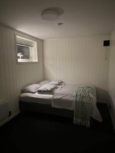 een kleine slaapkamer met een bed en een raam bij Apartment with a unique view, center of Kvaløya in Tromsø