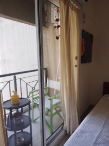 1 dormitorio con balcón con 1 cama y 1 mesa en Departamento Almagro en Buenos Aires