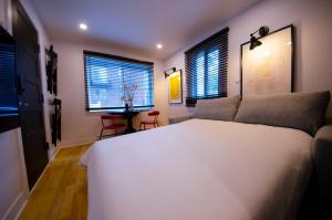 a bedroom with a large white bed and two windows at Mila Downtown Home in Montreal