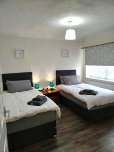 1 dormitorio con 2 camas y ventana en Comfort Private Rooms in Three bedroom House en Bridgemary