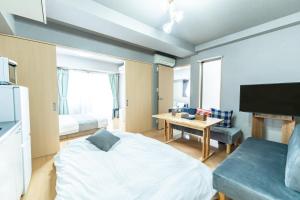 a room with a bed and a table and a tv at Sun Route Hirano-cho, サンルート平之町 in Kagoshima