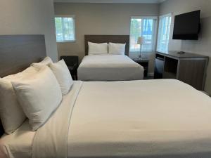 a hotel room with two beds and a television at Ocean Park Inn in Los Angeles