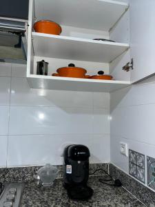 eine Küche mit einer Arbeitsplatte mit Töpfen auf Regalen in der Unterkunft Bel appartement in Tangier