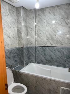 ein Badezimmer mit einem WC und einer Badewanne in der Unterkunft Bel appartement in Tangier