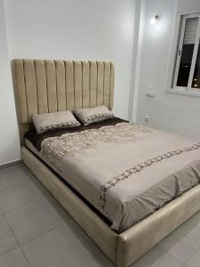 ein großes Bett mit einem großen Kopfteil in einem Schlafzimmer in der Unterkunft Bel appartement in Tangier