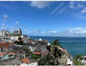uma vista para uma cidade com o oceano e edifícios em Apartamento no circuito do carnaval em Salvador