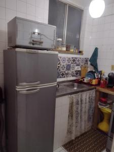 uma cozinha com um frigorífico de aço inoxidável e um lavatório em Apartamento no circuito do carnaval em Salvador