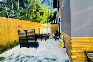 a patio with a fence and a table and chairs at Cozy house in Buena Vista Jarabacoa in Buena Vista