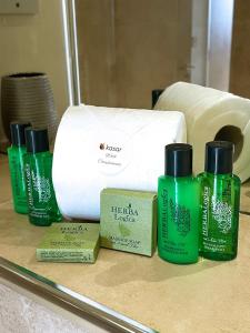 a group of four green bottles of toiletries on a counter at Maidstone Heights By Kasar Stays in Kent