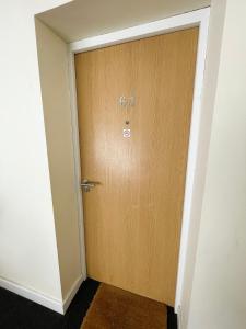 eine Holztür ohne Eingangsschild in der Unterkunft Maidstone Heights By Kasar Stays in Kent
