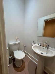 een witte badkamer met een toilet en een wastafel bij Tranquil Relaxing 2 Bed Apartment In Peterborough in Peterborough