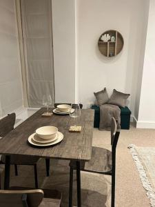 - une table à manger avec des assiettes et des verres à vin dans l'établissement Tranquil Relaxing 2 Bed Apartment In Peterborough, à Peterborough