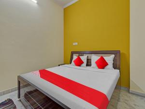 a bedroom with a bed with red and white pillows at OYO Flagship Hotel Hastinapur Residency in Jaipur