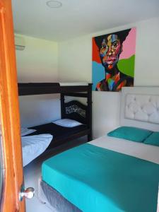 a room with two bunk beds and a painting on the wall at HOSPEDAJE FAMILAR CAMPESTRE "Villa Alondra" in Villavicencio