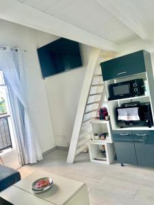 a living room with a stair case and a kitchen at Duplex Marina gosier- vue Mer et bateaux in Le Gosier