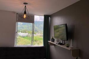 a living room with a television and a window at Buscas hospedarte en el Quindío in Armenia