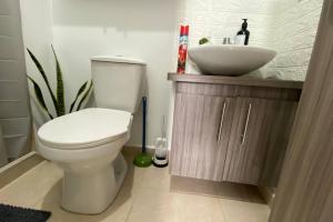 a bathroom with a white toilet and a sink at Buscas hospedarte en el Quindío in Armenia