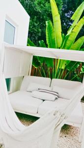 a white couch sitting in a swinging chair at Villa Kuxtah, Beautiful bungalow with Private Pool in Tulum