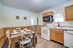 a kitchen with a wooden table and a white stove top oven at Jones Mills Vacation Rental Near Skiing and Hiking! 