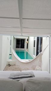 a hammock in a bedroom with a swimming pool at Villa Kuxtah, Beautiful bungalow with Private Pool in Tulum