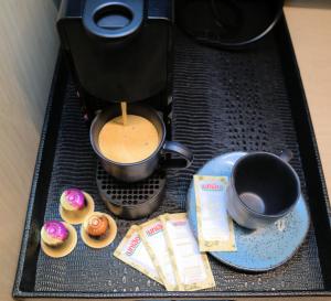 a coffee maker with cupcakes and a cupcake at HIGI HOTEL SÃO PAULO in Sao Paulo