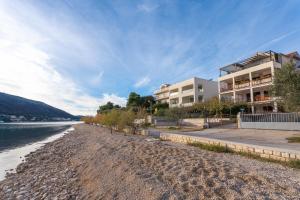 um edifício numa praia ao lado de um corpo de água em Apartments and rooms by the sea Grebastica, Sibenik - 13942 em Grebaštica