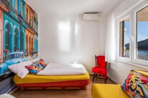 sypialnia z łóżkiem i czerwonym krzesłem w obiekcie Apartments and rooms by the sea Grebastica, Sibenik - 13942 w mieście Grebaštica