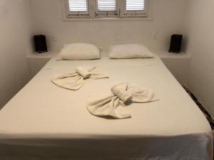 a bed with two white pillows on top of it at ITACUPA - Healthy VEGAN & FOIL Center in Cumbuco