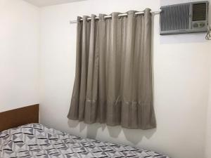 einen Vorhang in einem Zimmer mit einem Bett und einem Ventilator in der Unterkunft CASA COMPACTA NO PRIVÊ COQUEIRAL COM GARAGEM in Recife