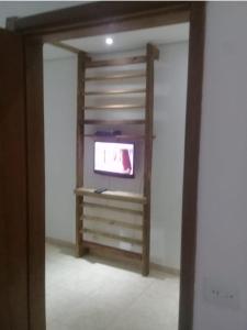 a living room with a tv in a wall at Suites Baleia Verde in São Sebastião