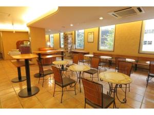 um restaurante com mesas e cadeiras num quarto em R&B Hotel Sapporo Kita 3 Nishi 2 - Vacation STAY 39507v em Sapporo