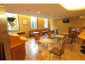 um restaurante com mesas e cadeiras num quarto em R&B Hotel Sapporo Kita 3 Nishi 2 - Vacation STAY 39507v em Sapporo
