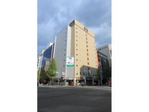 um edifício alto numa rua numa cidade em R&B Hotel Sapporo Kita 3 Nishi 2 - Vacation STAY 39507v em Sapporo