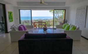 a living room with couches and a view of the ocean at Residence Nativa Las Vistas, appartement in Tarcoles