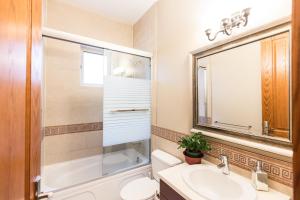 a bathroom with a sink and a toilet and a mirror at An Yang House in Burnaby