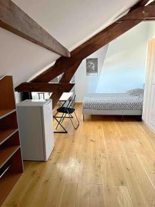 a attic room with a bed and a desk at 7 chambres Paris Disneyland in Chelles