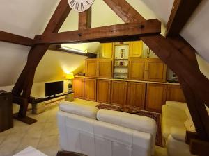 a living room with a white couch and a clock at Voici une suggestion de titre : Gîte charmant près de Nancy avec climatisation, WiFi, barbecue et parking privé - FR-1-584-100 in Thelod