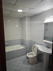 La salle de bains est pourvue de toilettes, d'un lavabo et d'une baignoire. dans l'établissement Sea View Studio, à Ajman