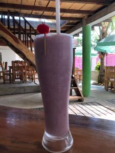 une boisson assise sur une table avec une cerise dedans dans l'établissement ECOHOTEL LILI, à Puerto Limón