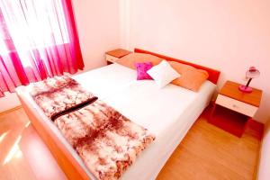 Schlafzimmer mit einem Bett mit weißer Bettwäsche und Kissen in der Unterkunft Apartments with a parking space Njivice, Krk - 21773 in Njivice