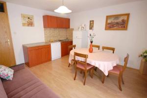 eine Küche und ein Esszimmer mit einem Tisch und Stühlen in der Unterkunft Apartments with a parking space Njivice, Krk - 21773 in Njivice