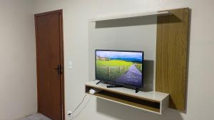 a flat screen tv sitting on a shelf in a room at Conforto e tranquilidade no centro in Foz do Iguaçu