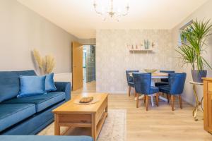 a living room with a blue couch and a table at Luxurious Scottish Apartment in Perth